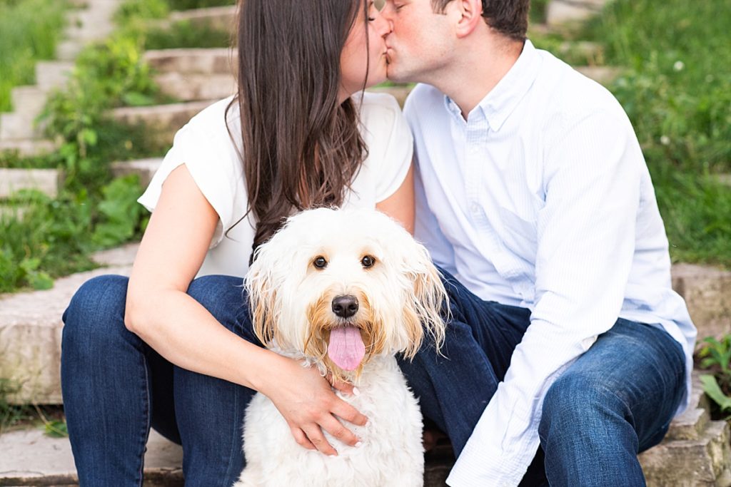 Couple poses along the steps with their dog