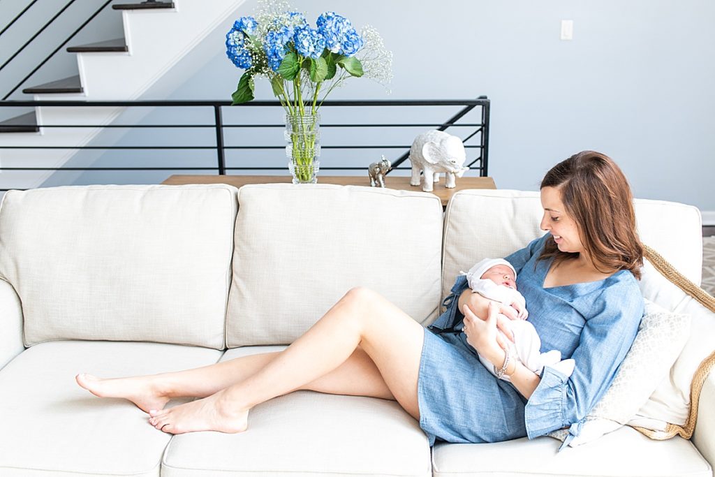 Mom and newborn snuggle up at home together