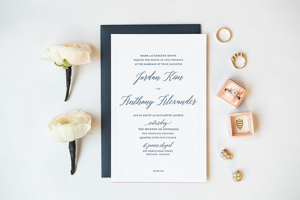 Detailed shot of the wedding invitation and wedding bands