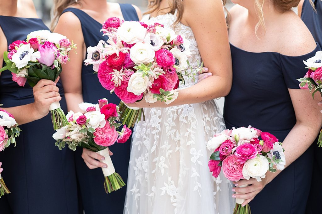 A pop of pink in the white floral bouquets