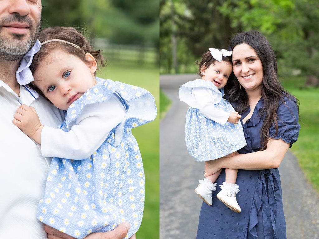 Girl in blue and white daisy dress with mom and dad smiles at the camera 