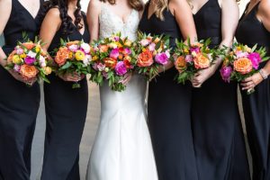 Bridesmaids in black with colorful bouquets