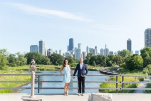 Man and woman smiling and facing the camera with the Chicago skyline in the background