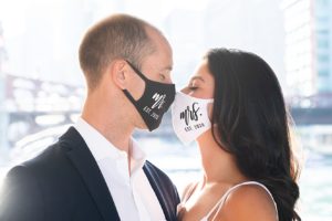 Couple posing facing each other while both wearing masks for the Covid-19 pandemic.