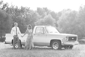 Man and woman hold hands in front of vintage Chevrolet truck at Shelby Farms Park in Memphis, Tennessee