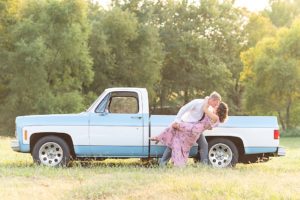 Man and woman dramatically kissing in front of vintage Chevy truck in a field at Shelby Farms Park in Memphis, Tennessee