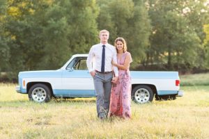 Photo of man and woman in a field in front of a vintage Chevy truck during anniversary session.