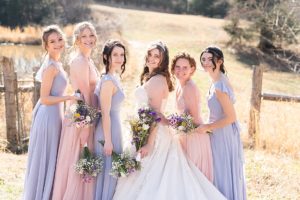 bride and bridesmaids posing while looking at the camera and holding bouquets