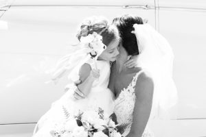 Photo of flower girl hugging bride