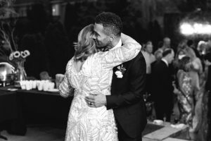 A groom dancing with his mother at his backyard wedding reception