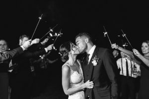 bride and groom kissing as they leave their wedding with a sparkler send off