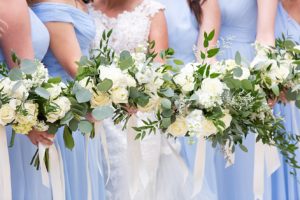 Bridesmaids in blue dresses with white and green bouquets