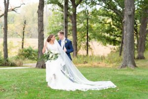 Photo of bride on a swing and groom standing near her