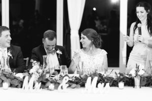 Bride and groom smile during wedding toasts