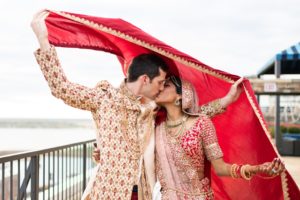 couple poses for wedding photos in traditional Indian wedding outfits