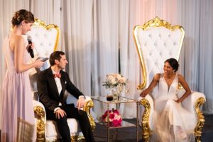 the brie and groom sat in lavish chairs at the wedding reception