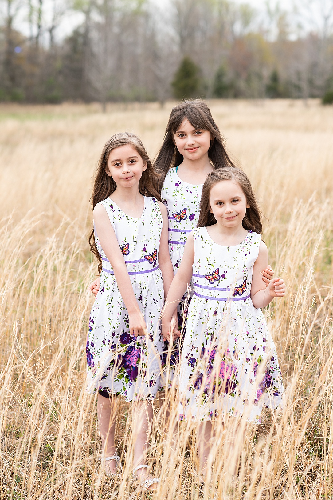 three girls in spring floral dresses posing for family photos