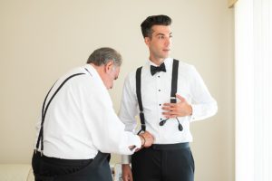 the groom was helped into his tux by his father